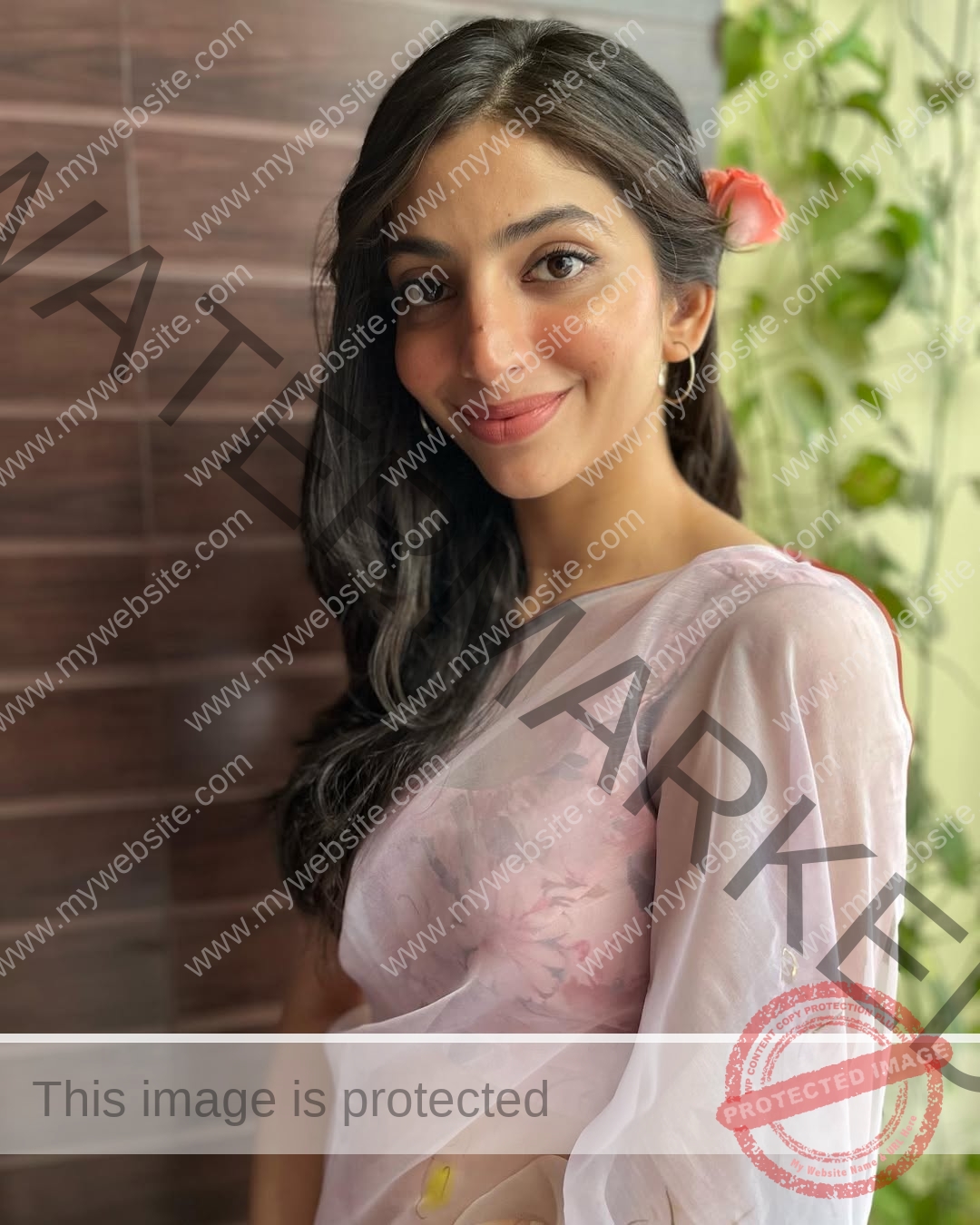 niharika-vashisht-india-niharika.vashhisht-05447 Niharika Vashisht, track and field star from India, in a light pink floral saree, smiles softly with a pink flower in her hair.