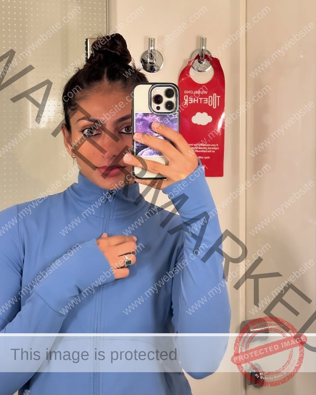 niharika-vashisht-india-niharika.vashhisht-05707 Niharika Vashisht, track and field star from India, wears a light blue zip jacket in a bathroom selfie; red Do Not Disturb sign behind.
