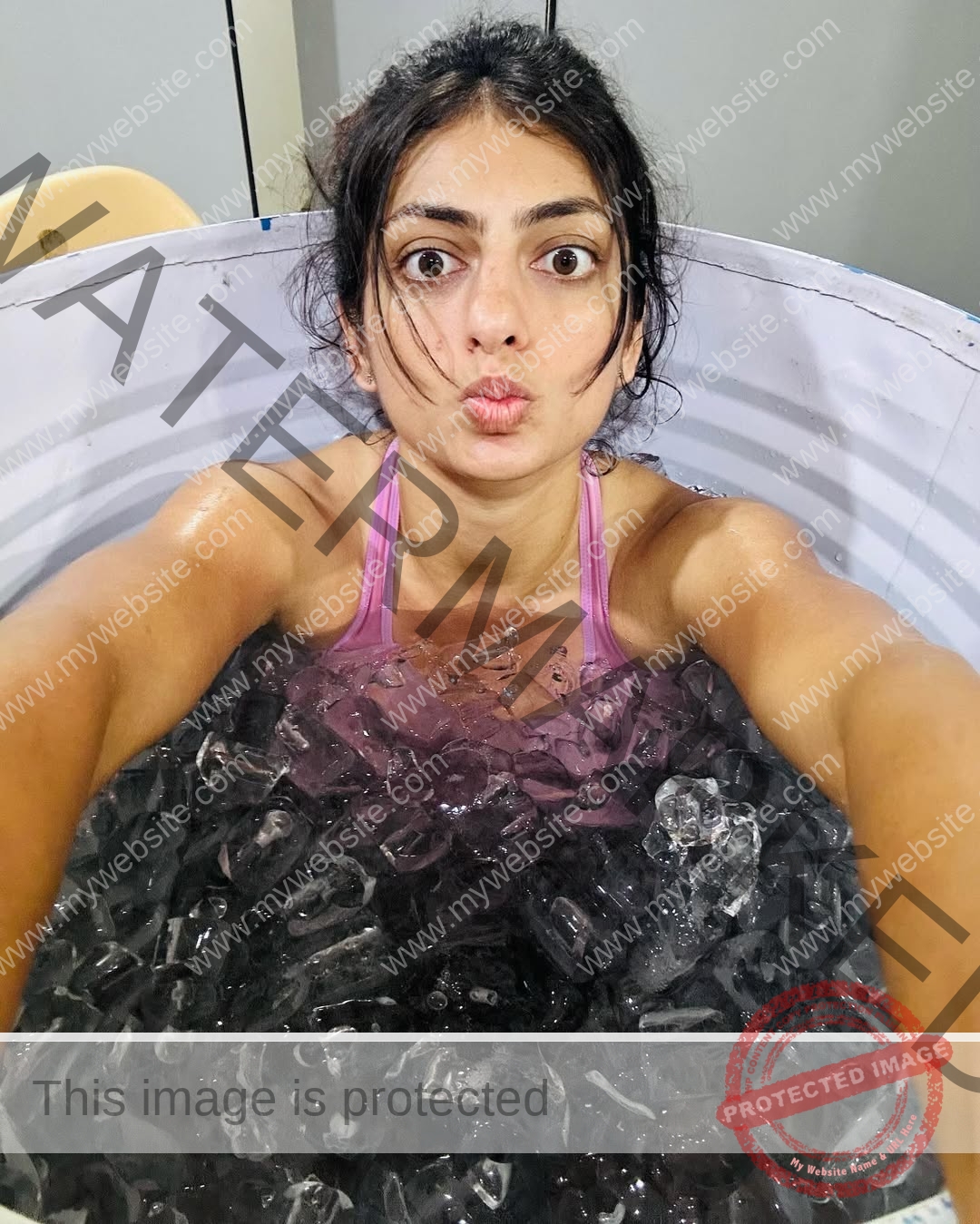 niharika-vashisht-india-niharika.vashhisht-05912 Niharika Vashisht, track and field star from India, sits in a tub of ice in a pink sports top, taking a selfie with puckered lips.