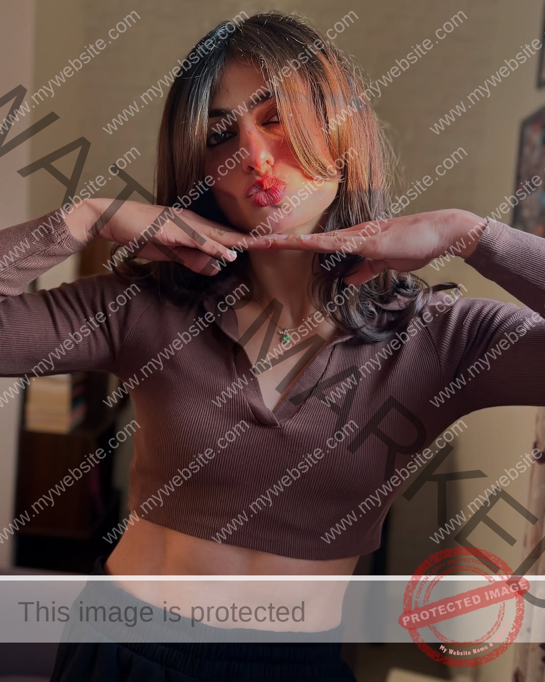 niharika-vashisht-india-niharika.vashhisht-05976 Niharika Vashisht, track and field star from India, with shoulder-length hair in a brown crop top, poses indoors making a playful kissy face.