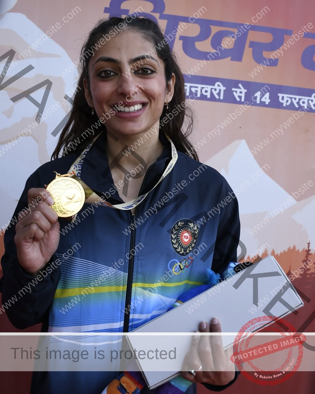 niharika-vashisht-india-niharika.vashhisht-06007 Niharika Vashisht, track and field star from India, in a sports jacket, smiles holding a gold medal and box before a Hindi backdrop.