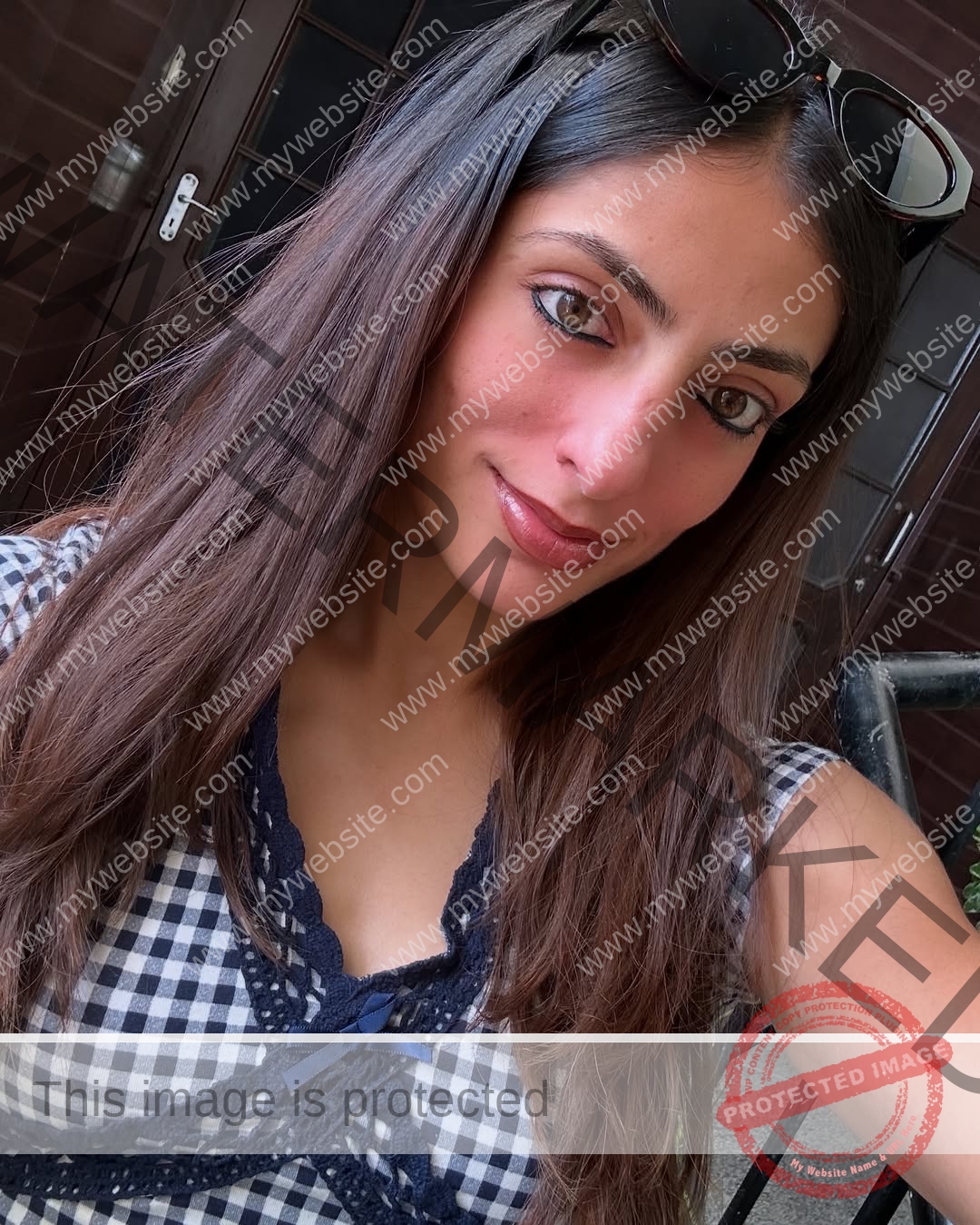 niharika-vashisht-india-niharika.vashhisht-06069 Niharika Vashisht, track and field star from India, with long brown hair and sunglasses on her head, smiles in a selfie by a wooden door.