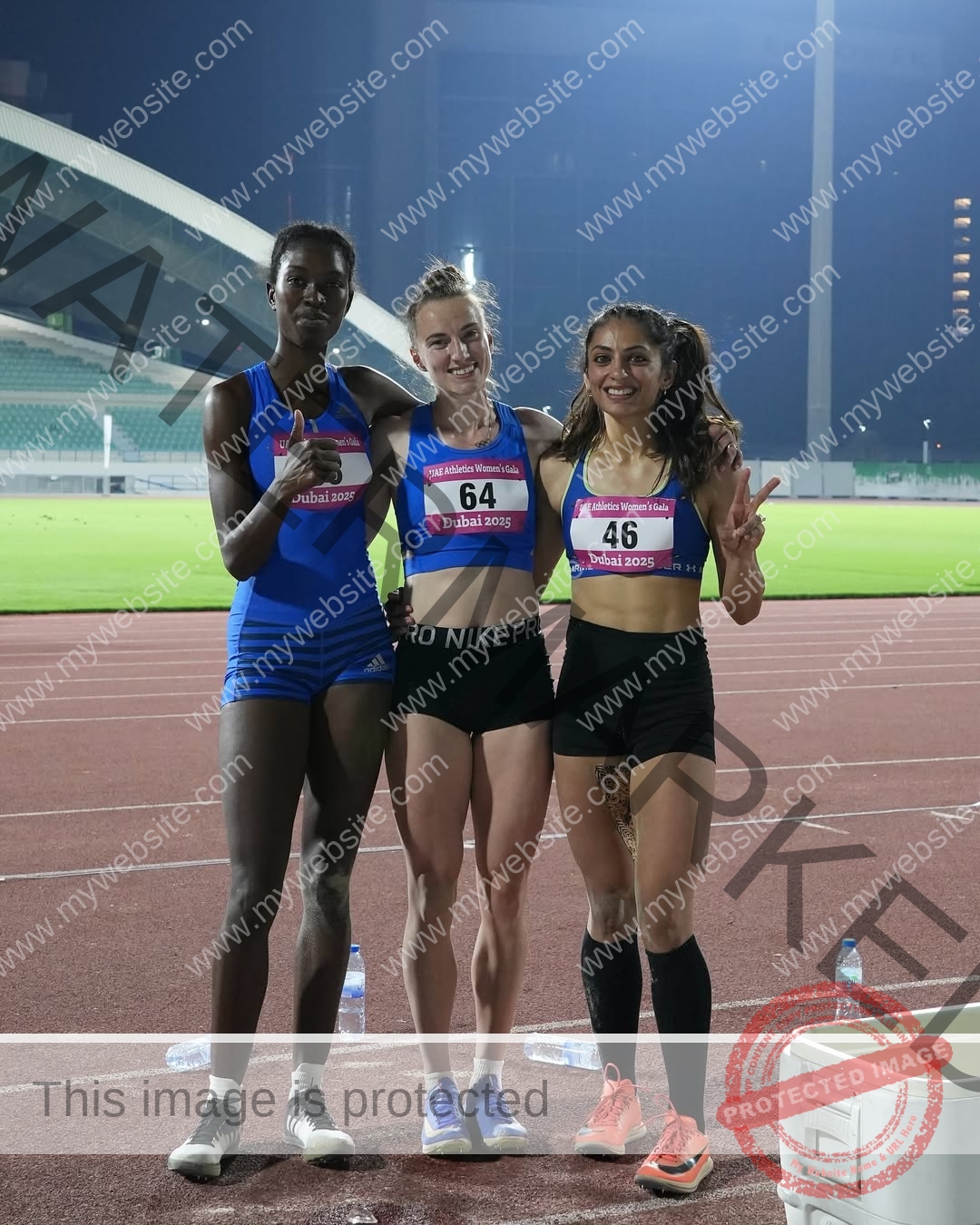 niharika-vashisht-india-niharika.vashhisht-06099 Niharika Vashisht, track and field star from India 'Three female athletes in running gear pose together on a track at night, smiling.'.