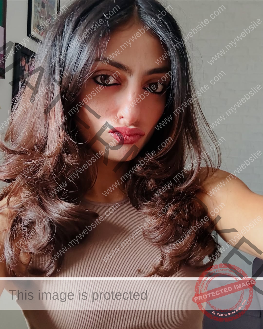 niharika-vashisht-india-niharika.vashhisht-06230 Niharika Vashisht, track and field star from India, with long wavy brown hair and a brown sleeveless top poses for a selfie indoors.