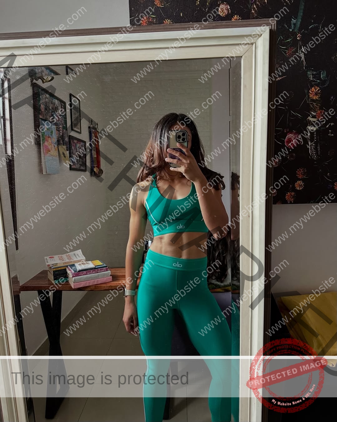 niharika-vashisht-india-niharika.vashhisht-06232 Niharika Vashisht, track and field star from India, in a green sports bra and leggings takes a mirror selfie, face hidden by phone.