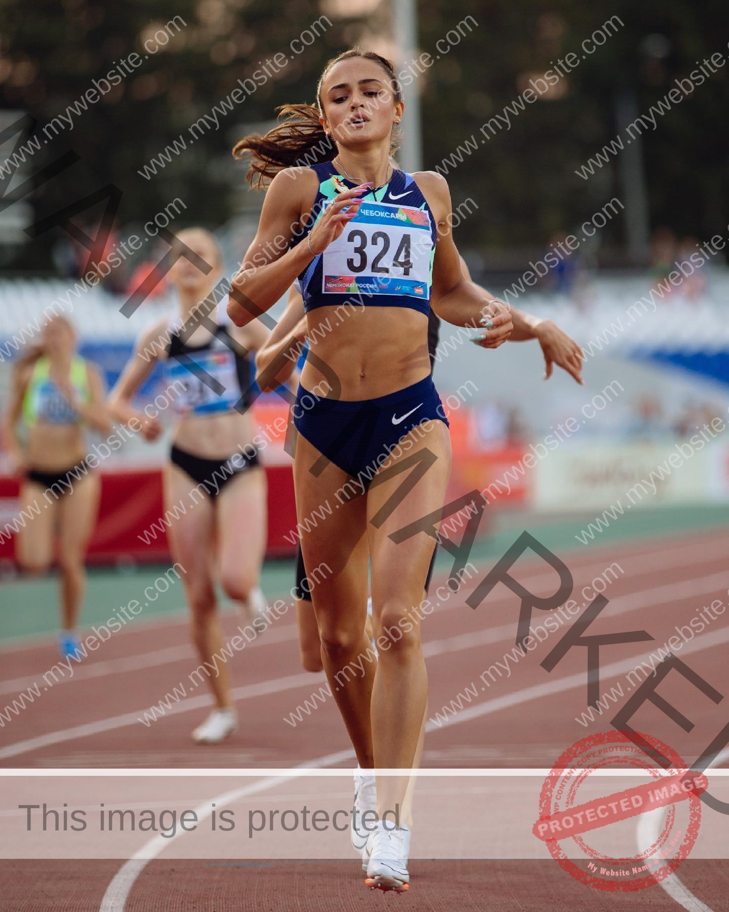 polina-tkalich-russia-p_a_tkalich-10822 Polina Tkalich, track and field star from Russia, sprints on a stadium track in blue Nike gear, baton in hand, runners behind.