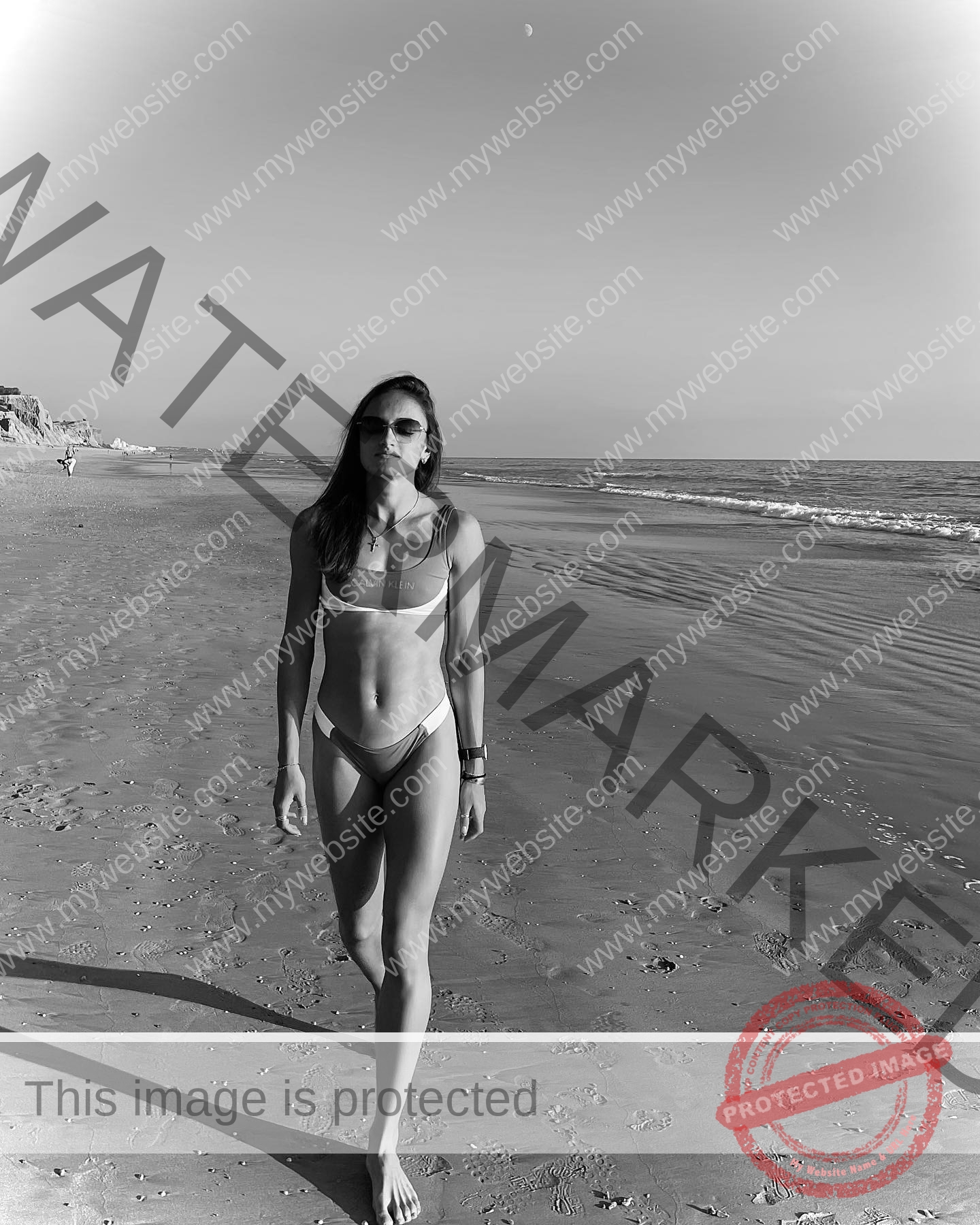polina-tkalich-russia-p_a_tkalich-10906 Polina Tkalich, track and field star from Russia walks barefoot in sunglasses and bikini on an empty, moonlit black-and-white beach.
