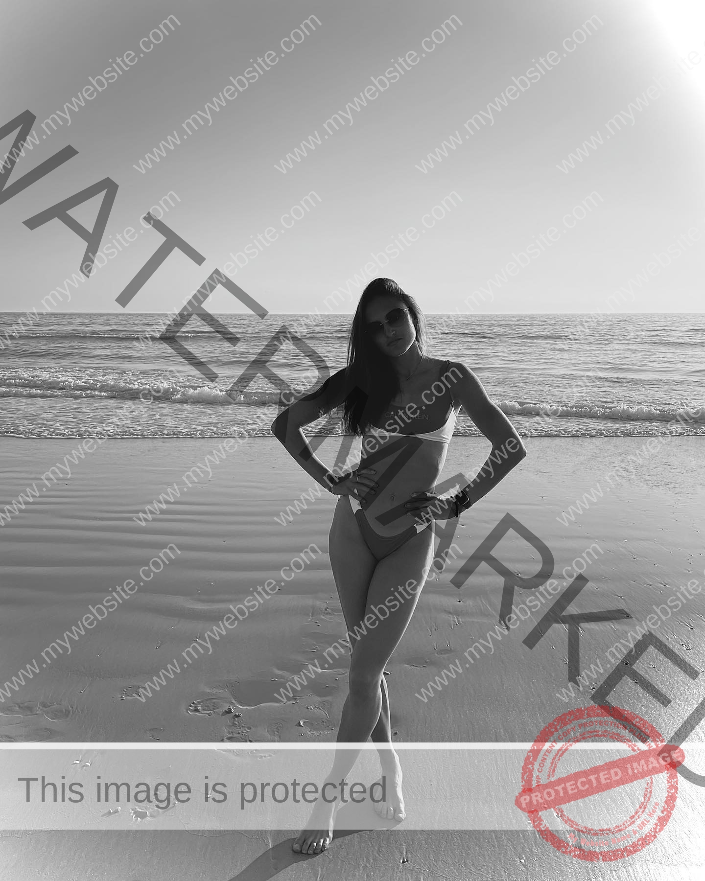 polina-tkalich-russia-p_a_tkalich-10907 Polina Tkalich, track and field star from Russia stands on wet sand in a bikini, ocean behind her, black and white photo.
