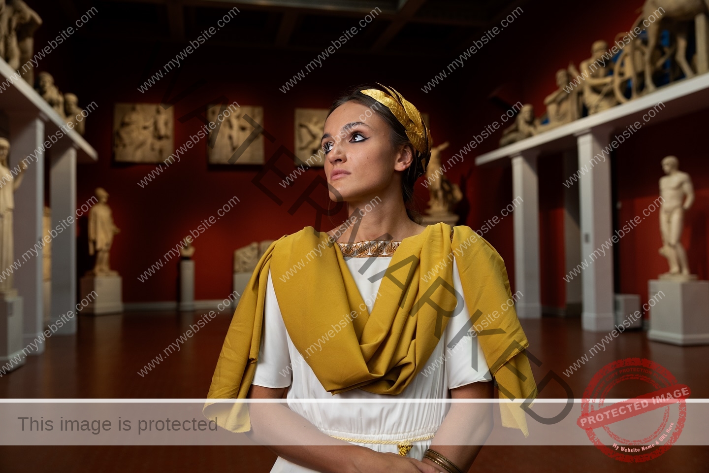 polina-tkalich-russia-p_a_tkalich-11256 Polina Tkalich, track and field star from Russia, stands in a white dress with yellow sash in a red-walled museum of statues.