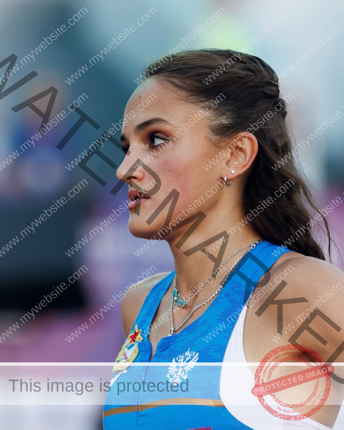 polina-tkalich-russia-p_a_tkalich-11268 Polina Tkalich, track and field star from Russia, with long brown hair in blue attire, looks focused left; blurred background.