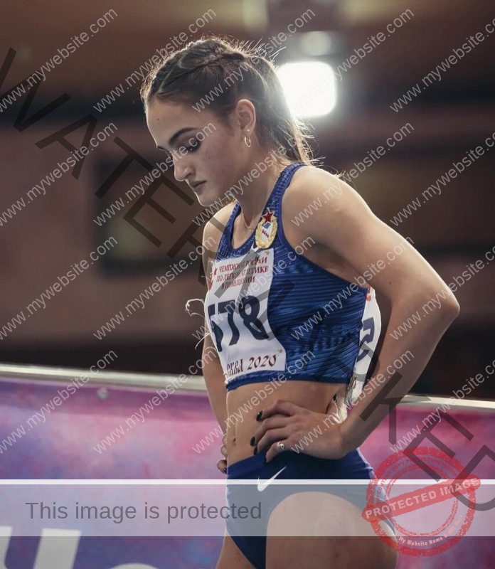 Polina Tkalich, track and field star from Russia, stands in blue sportswear, race number 178 visible, focused before her indoor race.