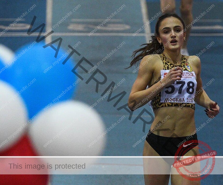 polina-tkalich-russia-p_a_tkalich-11517 Polina Tkalich, track and field star from Russia, runs on an indoor track in leopard-print top, black shorts, race number 578.