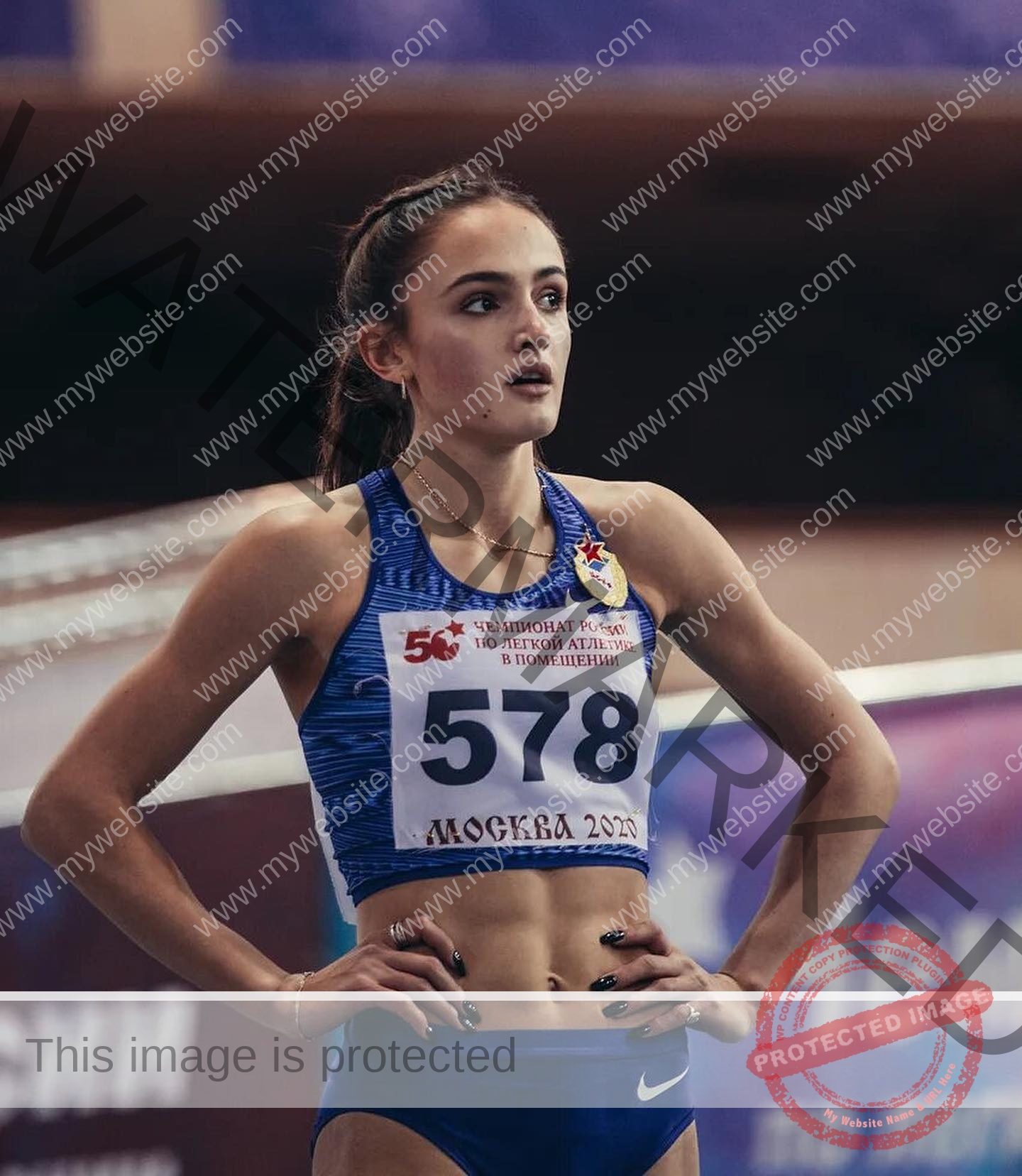 polina-tkalich-russia-p_a_tkalich-11524 Polina Tkalich, track and field star from Russia stands with hands on hips, bib 578, at a Moscow indoor track, looking focused.