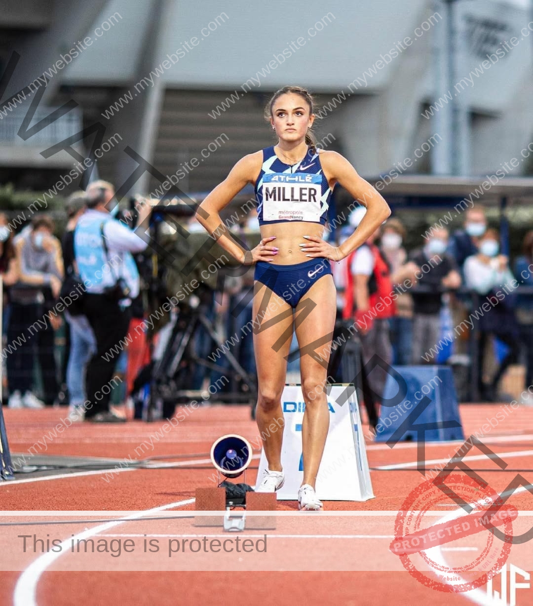 polina-tkalich-russia-p_a_tkalich-11796 Polina Tkalich, track and field star from Russia, stands confidently at the starting blocks in blue uniform, hands on hips.