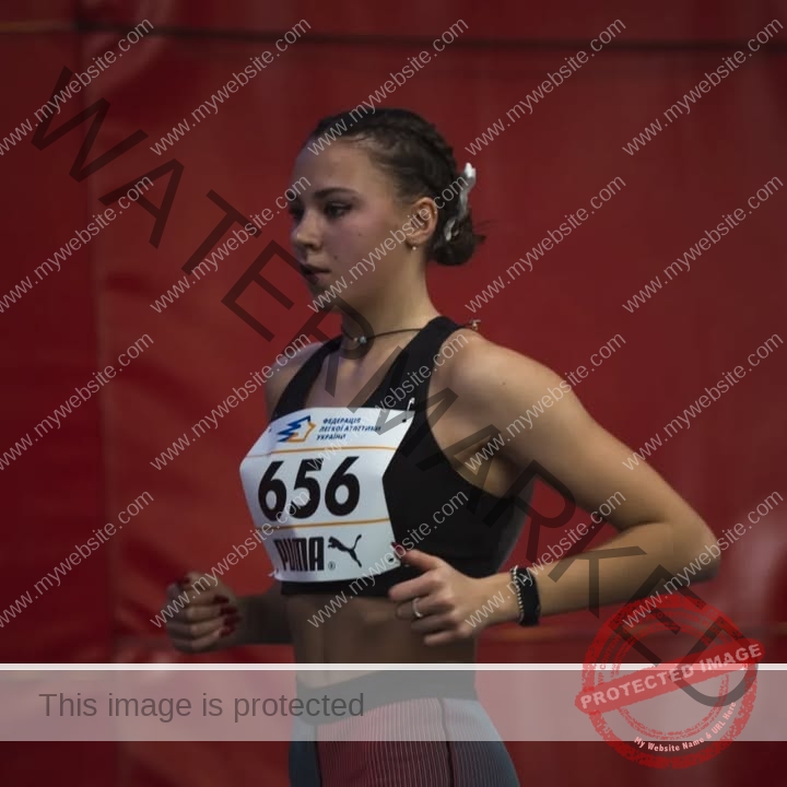 rufina-kotik-ukraine-rufina.kotik14-u18-02175 Rufina Kotik, track and field star from Ukraine, wears a black sports bra, striped leggings, and bib 656, ready to compete indoors.