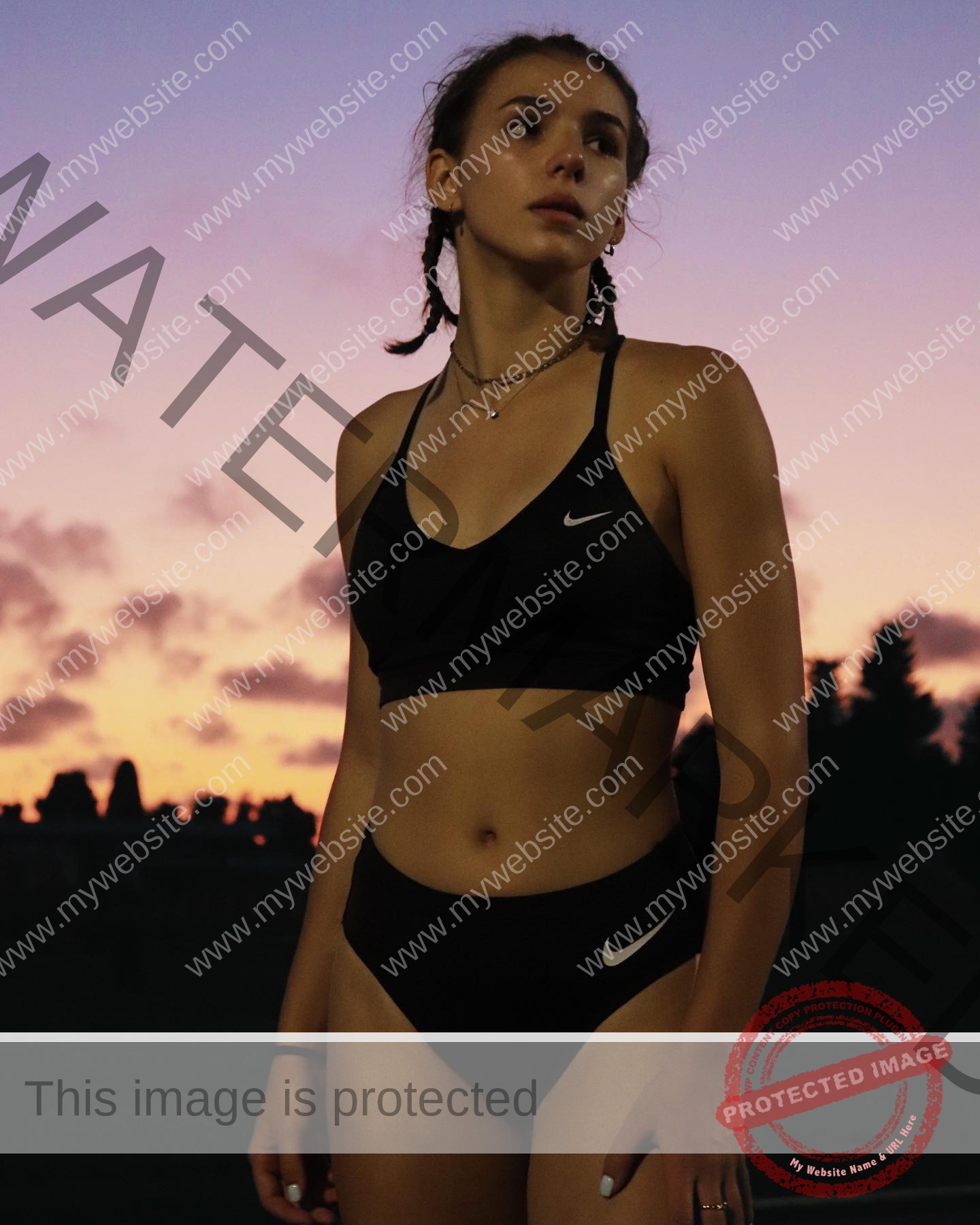 viktoriya-antipova-russia-viichkaaaaa-03525 Viktoriya Antipova, track and field star from Russia, in a black Nike sports bra and high-waisted bottoms at sunset under a purple-orange sky.