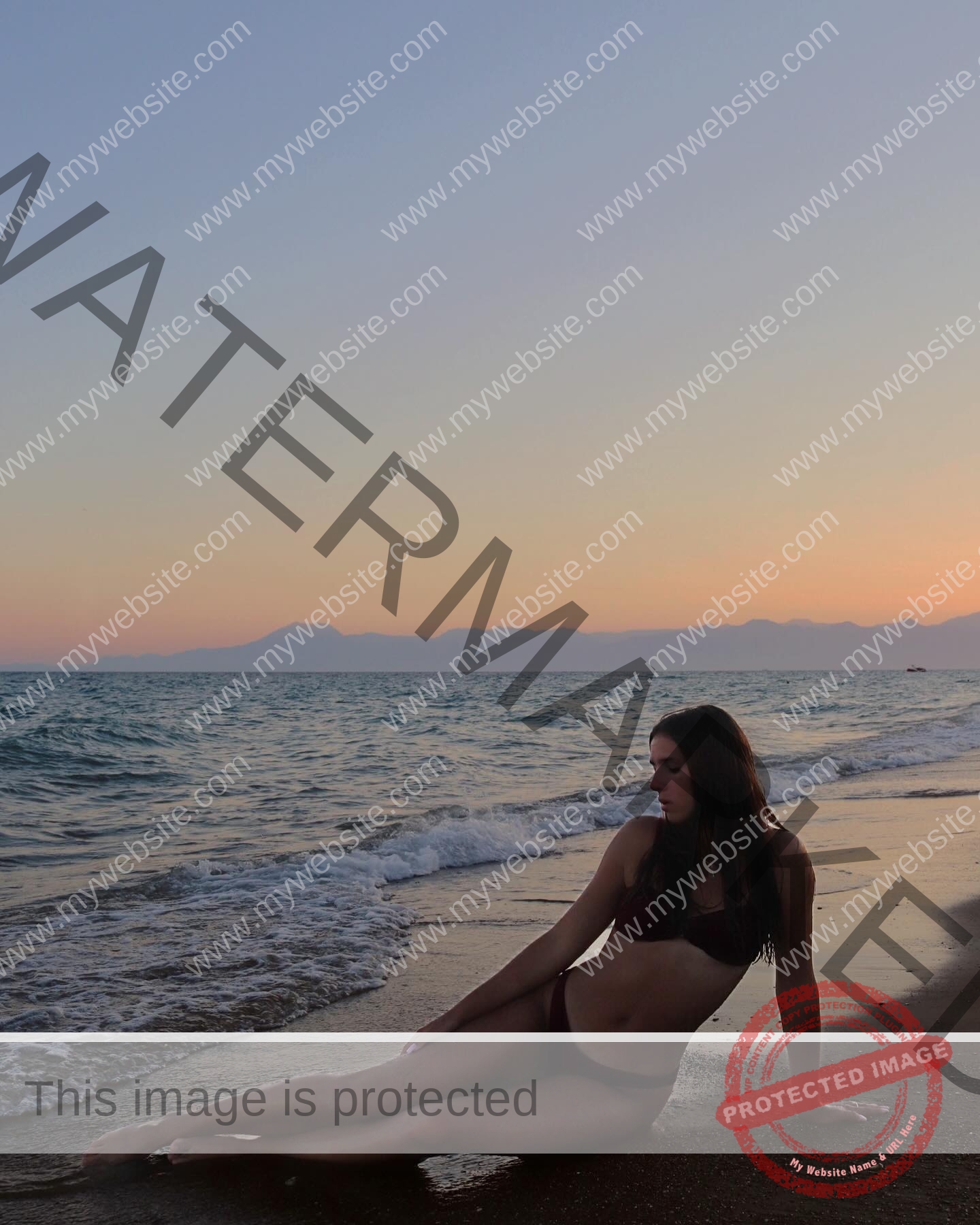 viktoriya-antipova-russia-viichkaaaaa-03662 Viktoriya Antipova, track and field star from Russia, sits in a dark bikini on wet sand at sunset, waves and mountains behind her.