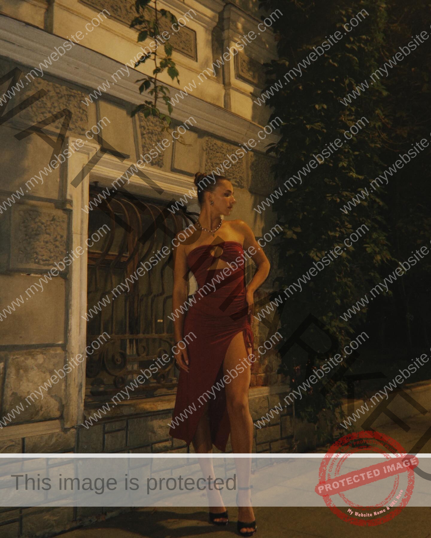 viktoriya-antipova-russia-viichkaaaaa-03666 Viktoriya Antipova, track and field star from Russia stands boldly in a red dress at night by an ivy-clad stone building.