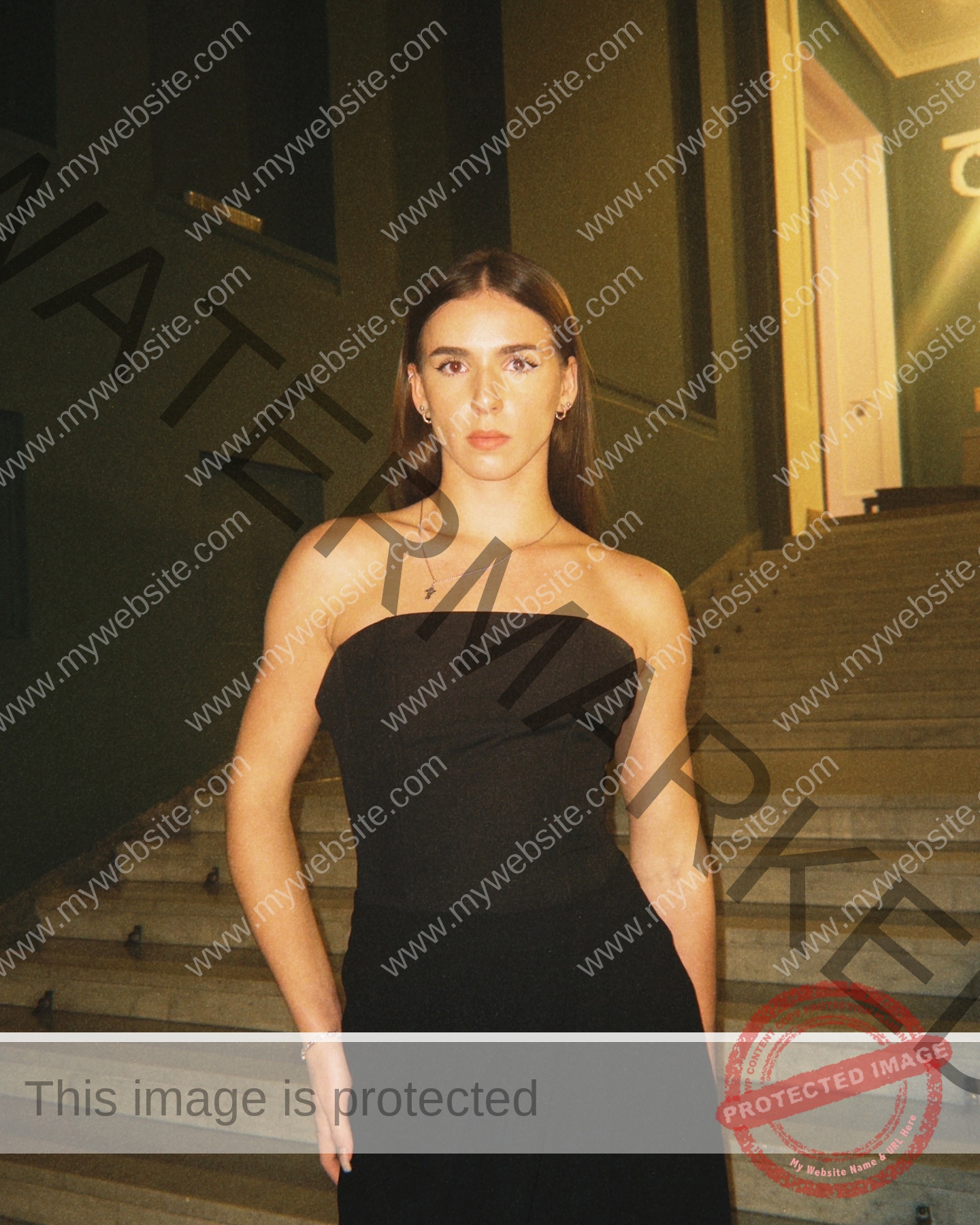 viktoriya-antipova-russia-viichkaaaaa-03687 Viktoriya Antipova, track and field star from Russia, stands on stone steps in a strapless black dress, posing confidently.