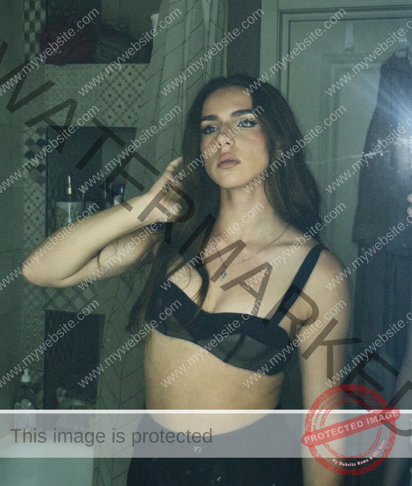 viktoriya-antipova-russia-viichkaaaaa-03739 Viktoriya Antipova, track and field star from Russia, poses in a black bra before a bathroom mirror, touching her hair. Shelves, curtain behind.