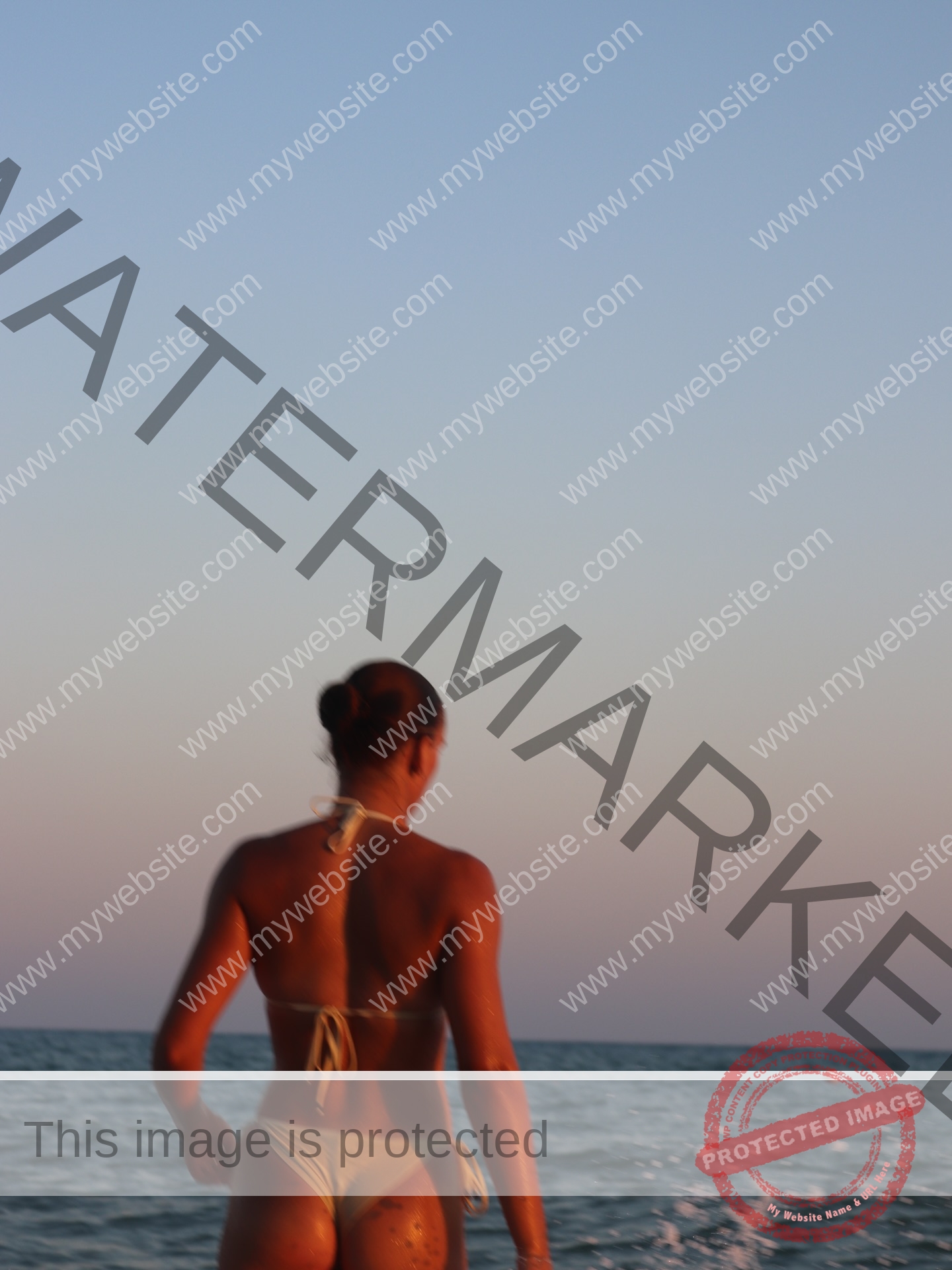 viktoriya-antipova-russia-viichkaaaaa-03772 Viktoriya Antapova, track and field star from Russia, walks in a bikini toward the ocean at sunset under a colorful sky.