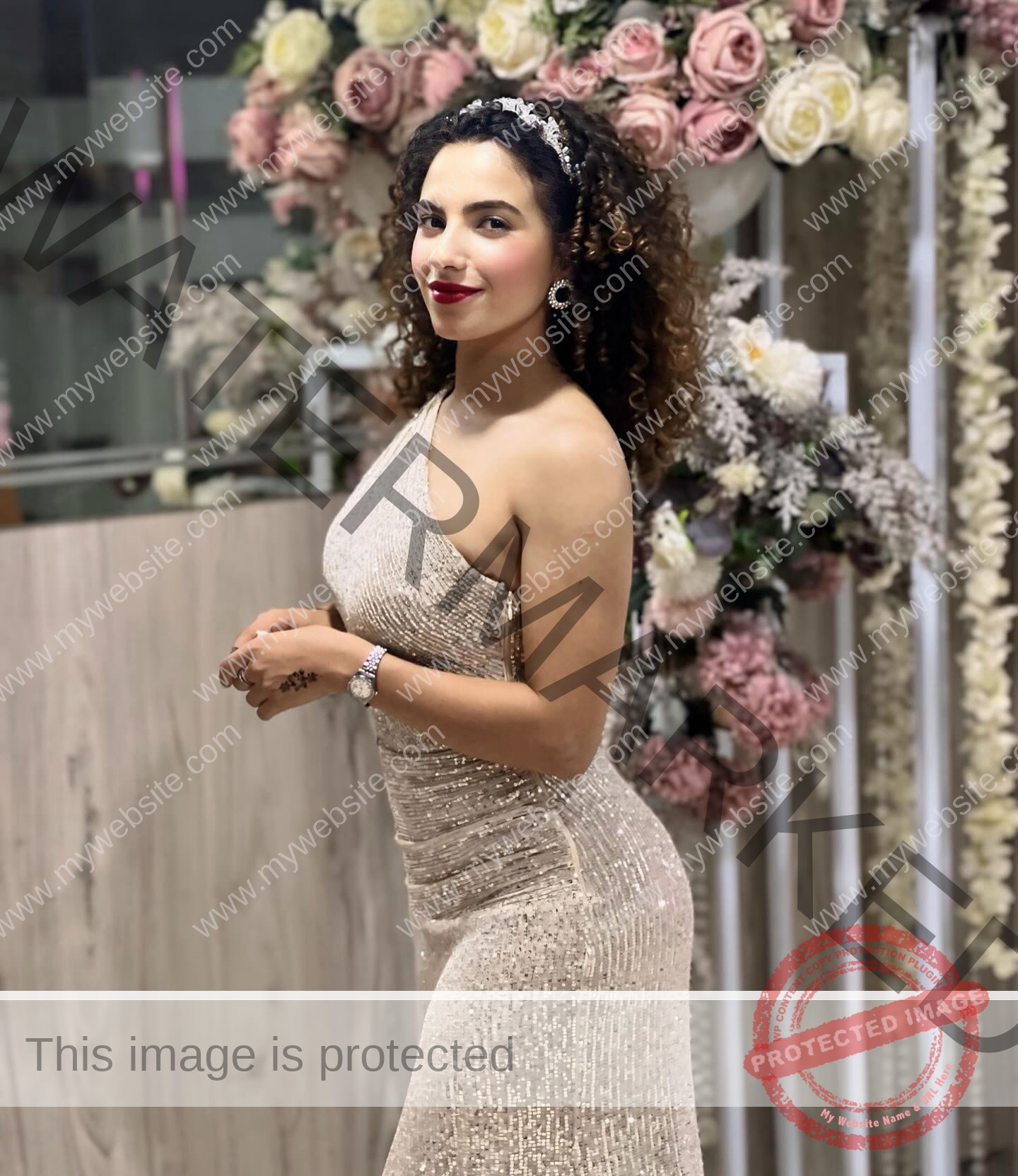 yassmine-baccar-tunisia-yassmine_baccar-08456 Yassmire Baccar, track and field star from Tunisia, stands smiling in a sparkling gown before pink and white roses, curly hair styled.