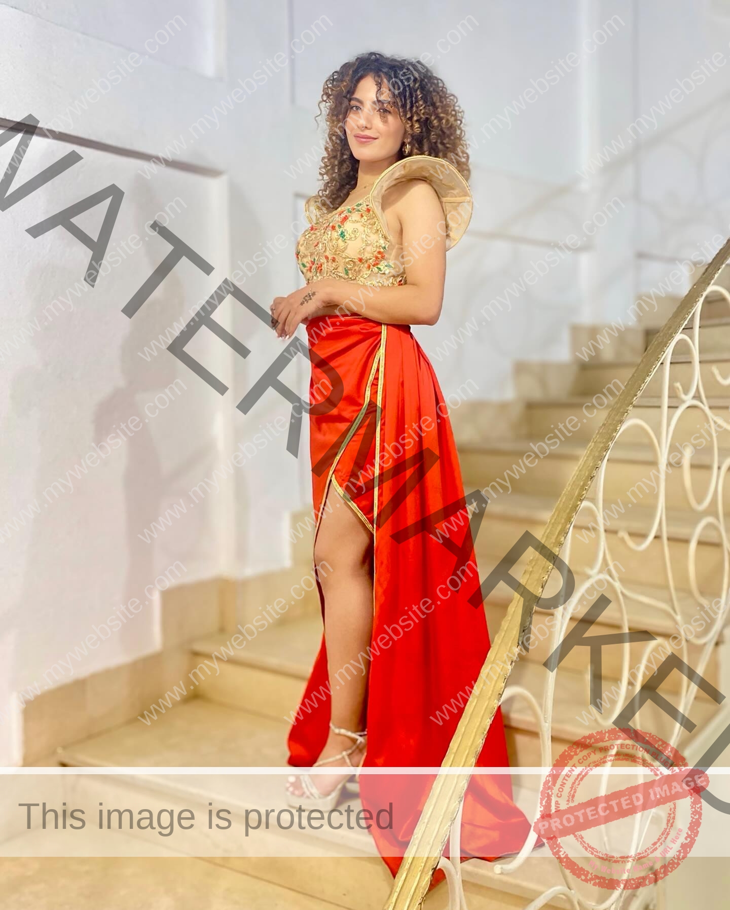 yassmine-baccar-tunisia-yassmine_baccar-08469 Yassmire Baccar, track and field star from Tunisia, stands on a staircase in a red and gold slit dress and strappy heels.